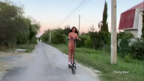 A naked girl rides a scooter through the streets and shocks passers-by naked on public